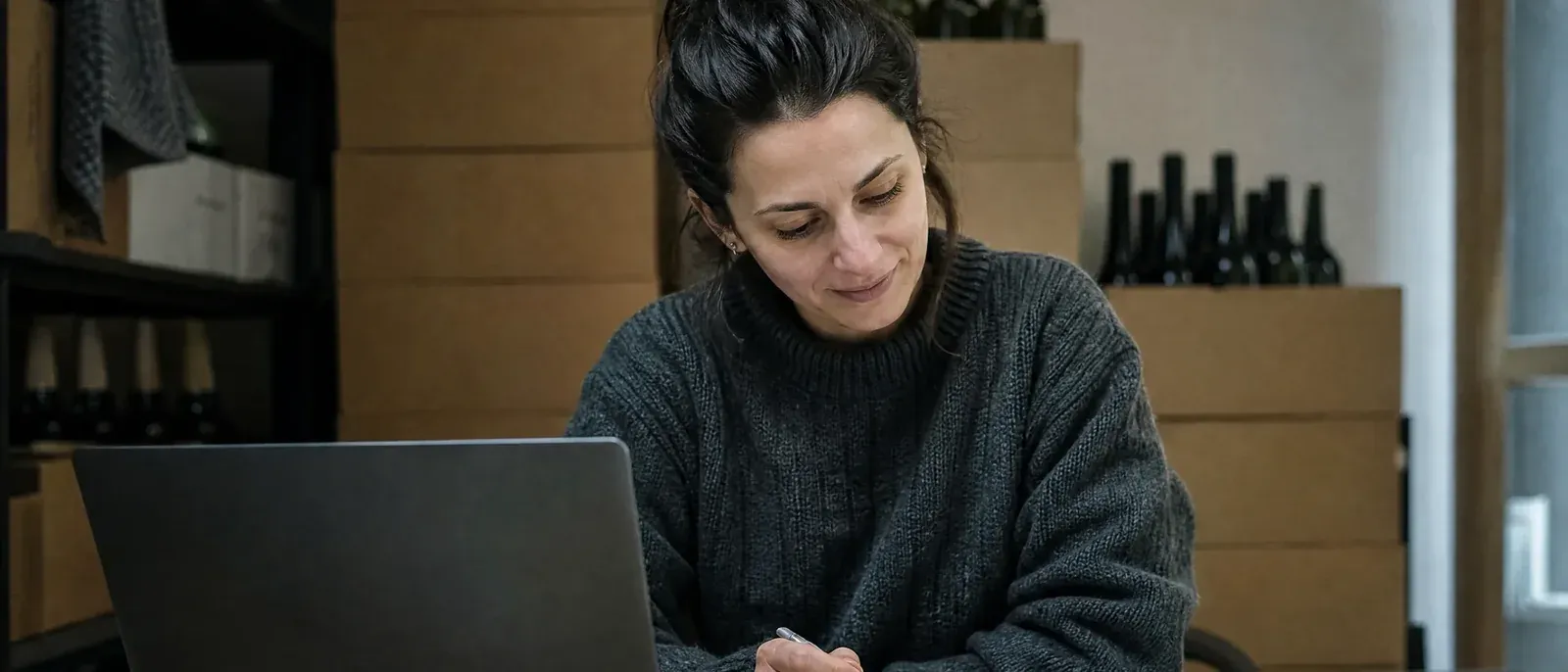 After closing, the owner of a small wine and deli shop checks an AI answer against her printed monthly sales summary.